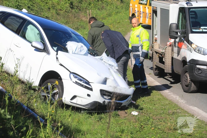 Auto vliegt uit de bocht en belandt op geluidswal