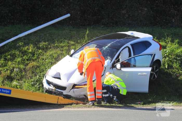 Auto vliegt uit de bocht en belandt op geluidswal