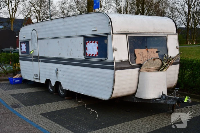 Handhaving sleept caravan met protesttekst weg van parkeerterrein gemeentewerf