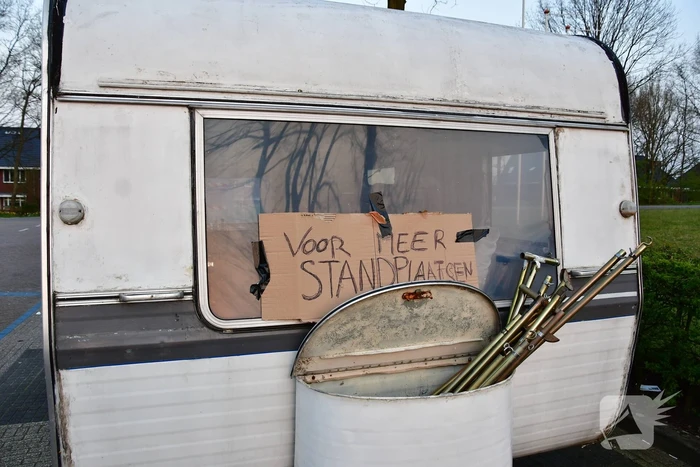 Handhaving sleept caravan met protesttekst weg van parkeerterrein gemeentewerf