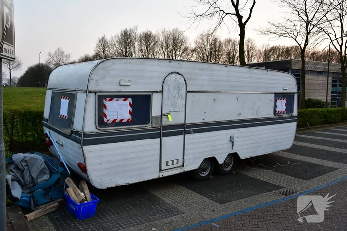 Handhaving sleept caravan met protesttekst weg van parkeerterrein gemeentewerf