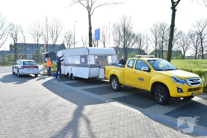 Handhaving sleept caravan met protesttekst weg van parkeerterrein gemeentewerf