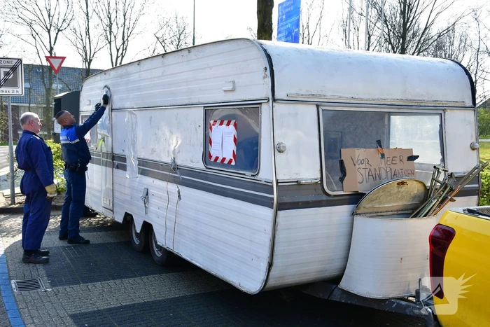 Handhaving sleept caravan met protesttekst weg van parkeerterrein gemeentewerf