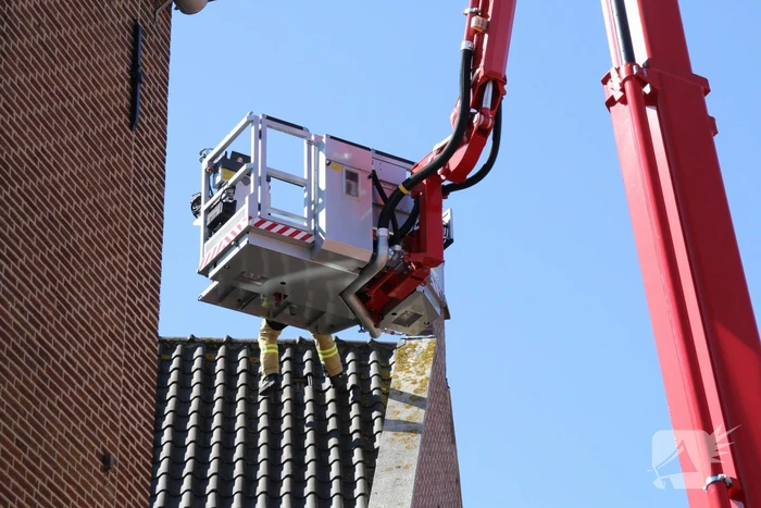 Brandweer verwijdert losliggende dakpannen winkelpand