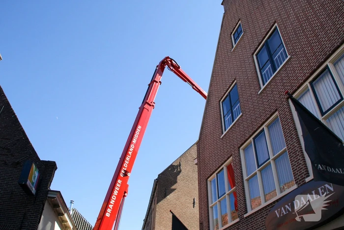 Brandweer verwijdert losliggende dakpannen winkelpand