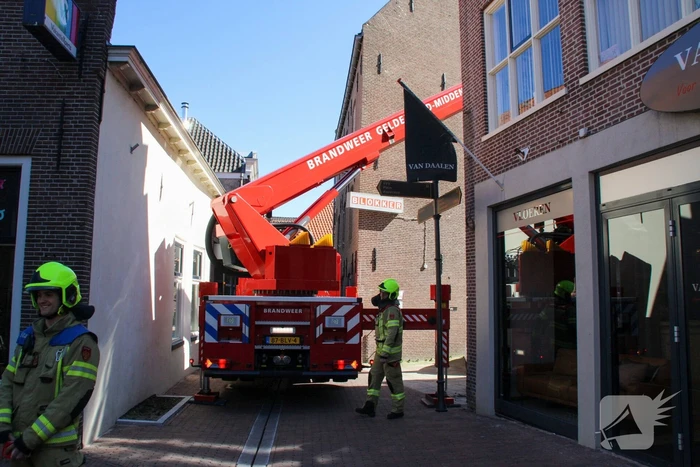 Brandweer verwijdert losliggende dakpannen winkelpand