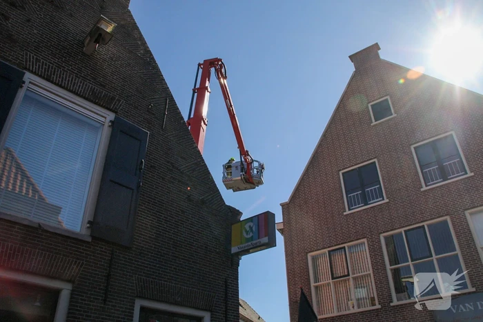 Brandweer verwijdert losliggende dakpannen winkelpand