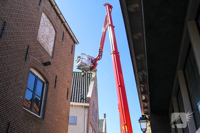 Brandweer verwijdert losliggende dakpannen winkelpand