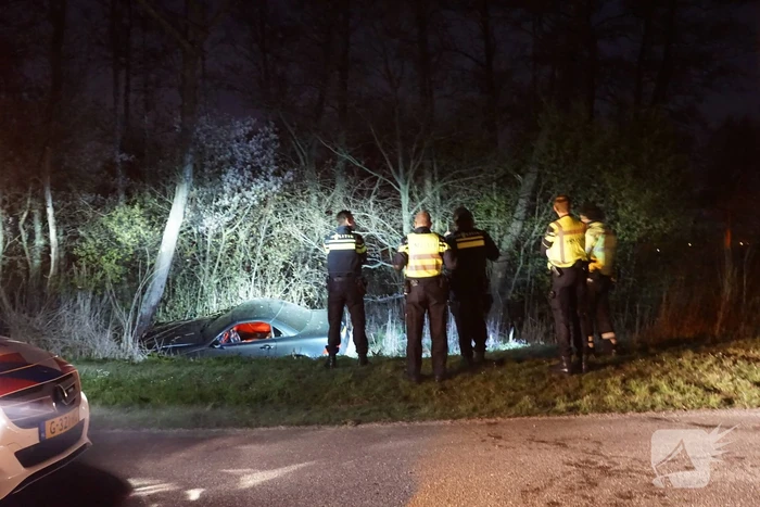 Auto te water, inzittende gewond