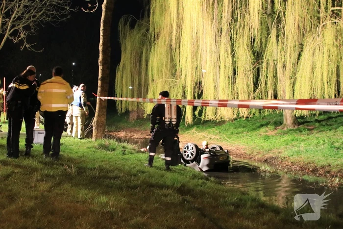 Auto te water bestuurder neemt de benen