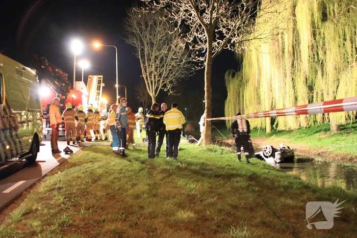 Auto te water bestuurder neemt de benen