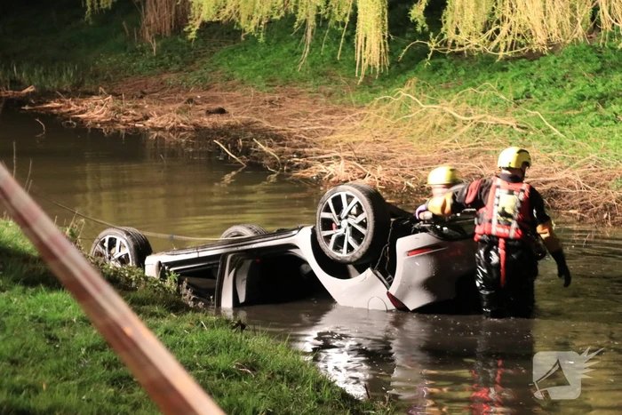 Auto te water bestuurder neemt de benen