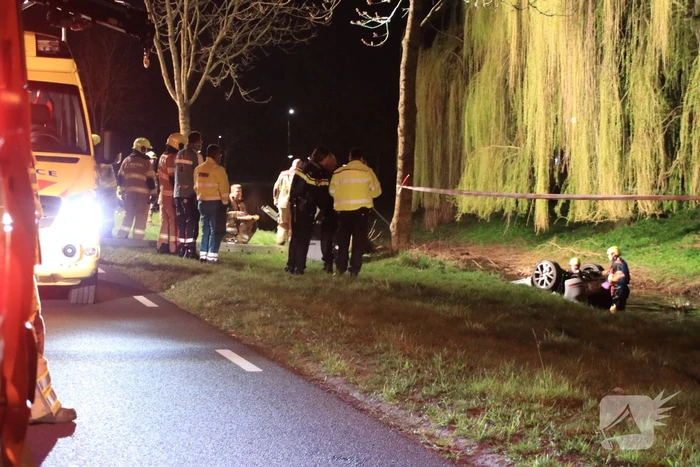 Auto te water bestuurder neemt de benen