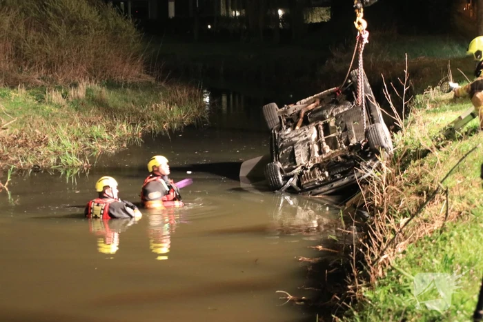 Auto te water bestuurder neemt de benen
