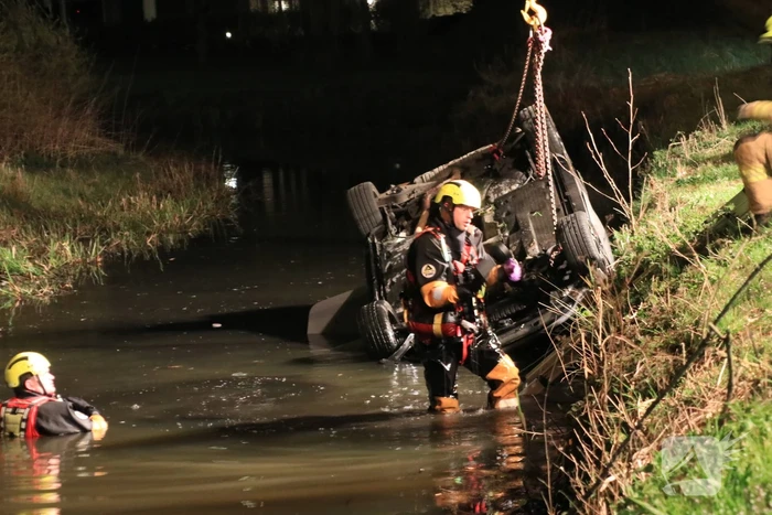 Auto te water bestuurder neemt de benen