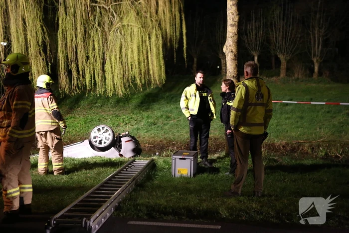 Auto te water bestuurder neemt de benen