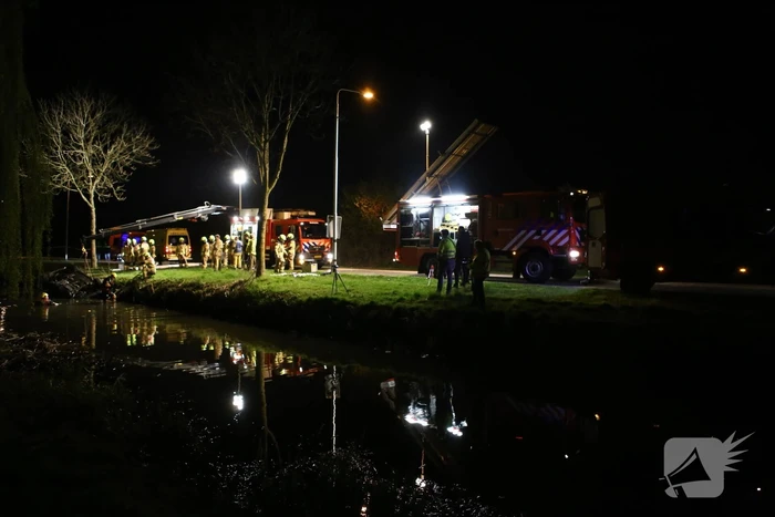 Auto te water bestuurder neemt de benen