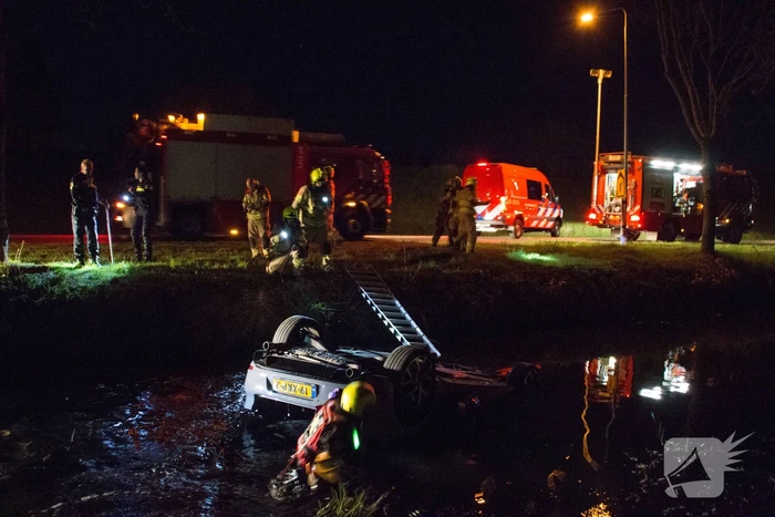 Auto te water bestuurder neemt de benen