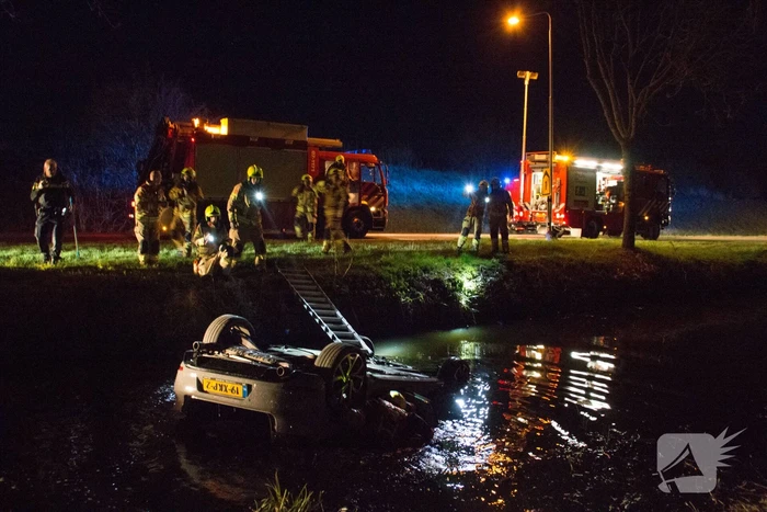 Auto te water bestuurder neemt de benen