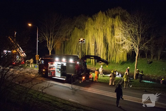 Auto te water bestuurder neemt de benen