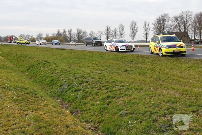 Bestelbus met aanhanger slaat over de kop