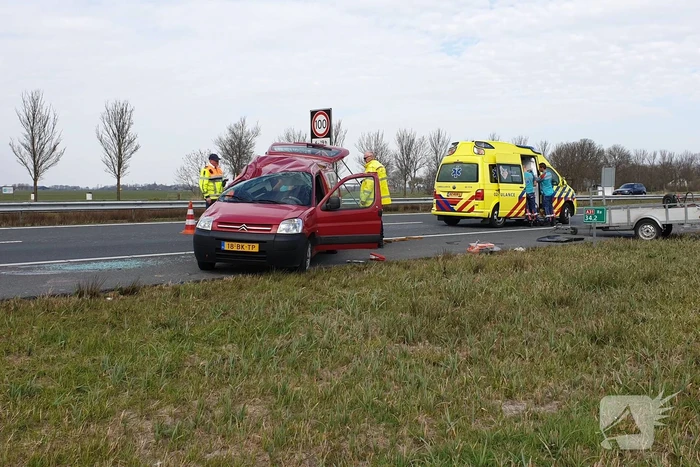 Bestelbus met aanhanger slaat over de kop