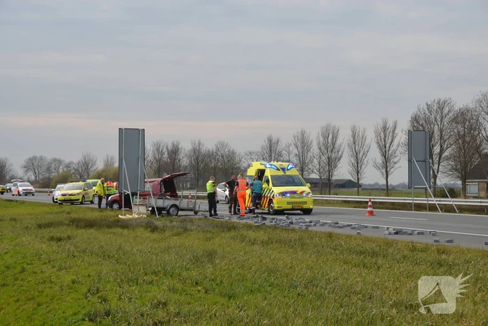 Bestelbus met aanhanger slaat over de kop