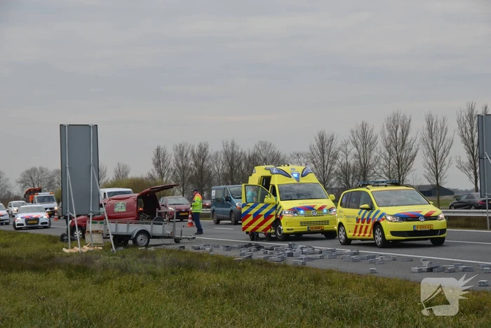 Bestelbus met aanhanger slaat over de kop