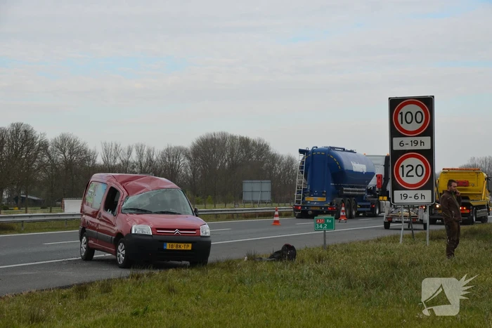 Bestelbus met aanhanger slaat over de kop