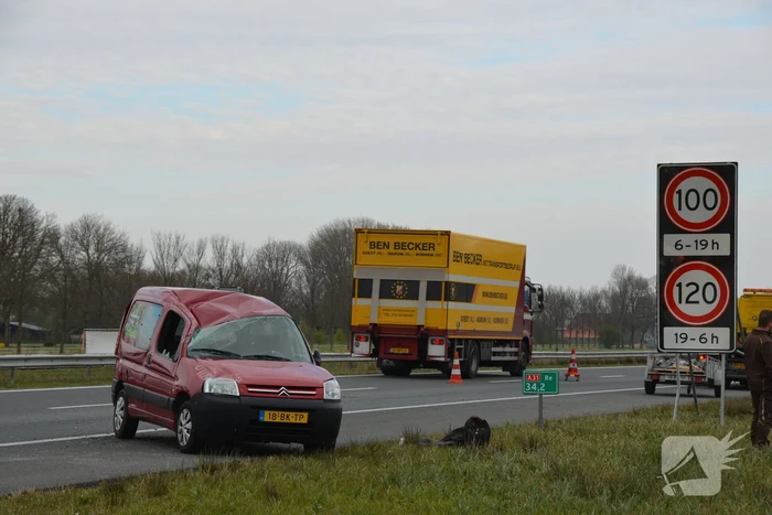 Bestelbus met aanhanger slaat over de kop