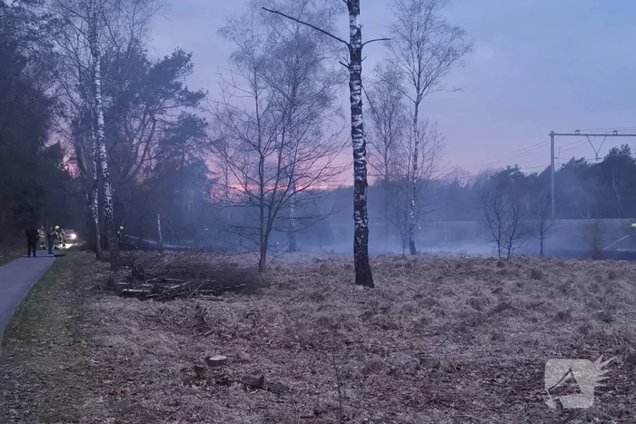 Groot stuk bosschage langs spoor in brand