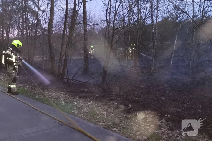 Groot stuk bosschage langs spoor in brand