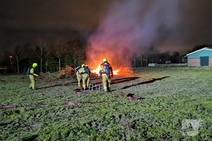 Berg met takken in weiland vatte vlam