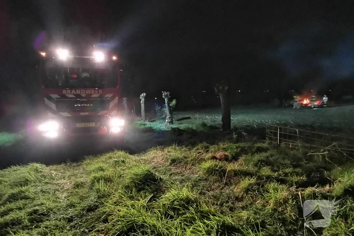 Berg met takken in weiland vatte vlam