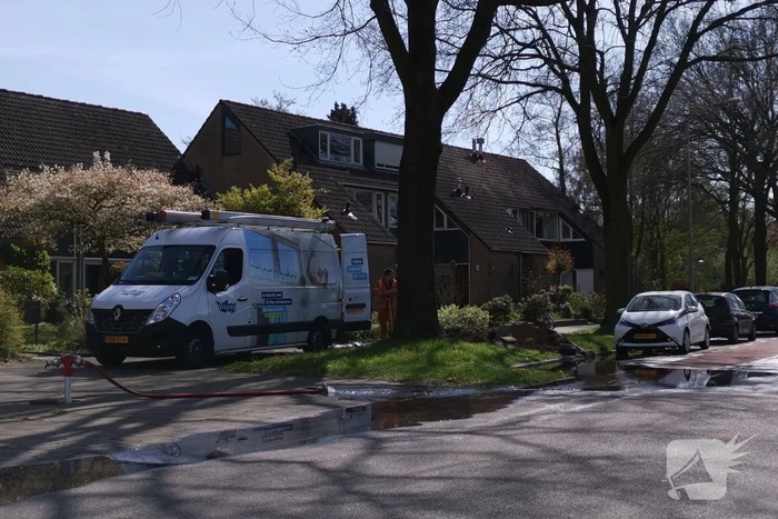 Water stroomt de weg op na leidingbreuk