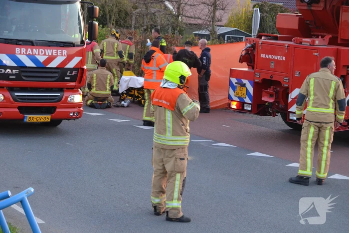 Man bekneld onder as van bedrijfswagen