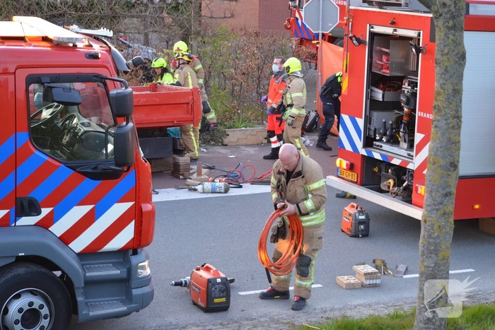 Man bekneld onder as van bedrijfswagen