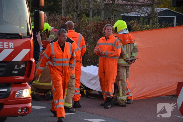 Man bekneld onder as van bedrijfswagen