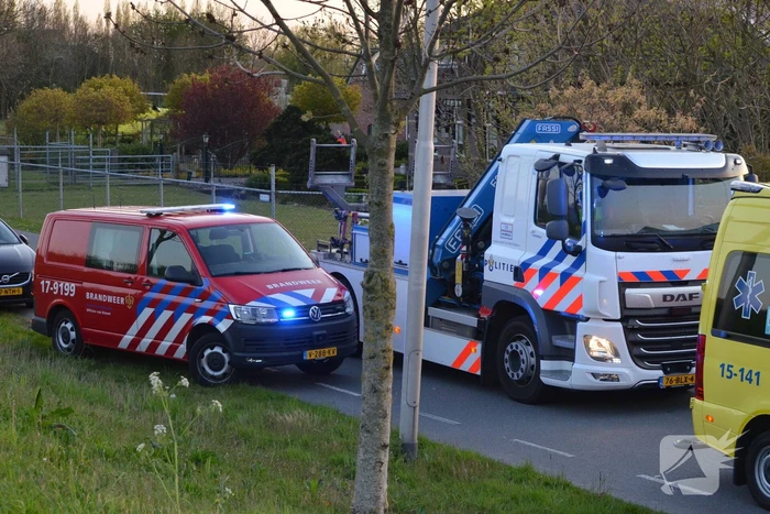 Man bekneld onder as van bedrijfswagen