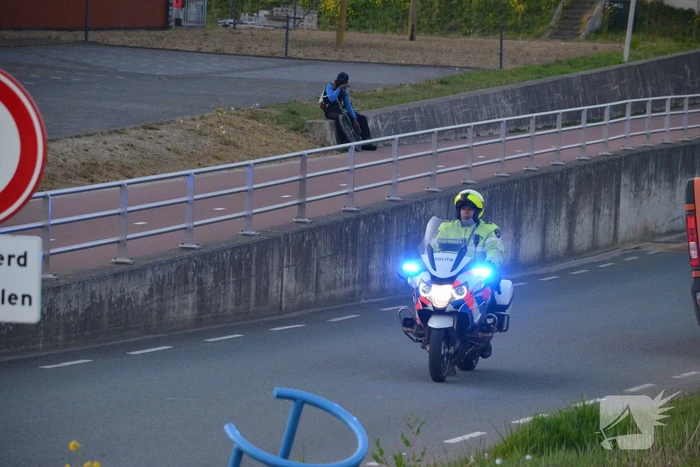 Man bekneld onder as van bedrijfswagen