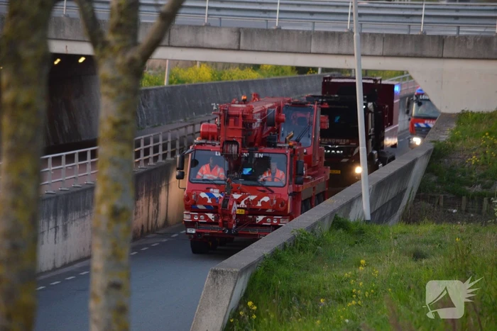 Man bekneld onder as van bedrijfswagen