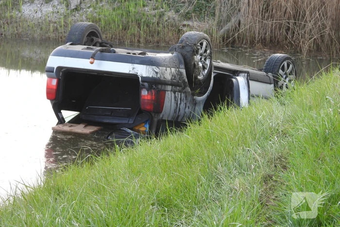 Auto op zijn kop in de sloot