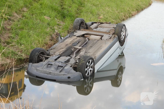 Auto op zijn kop in de sloot