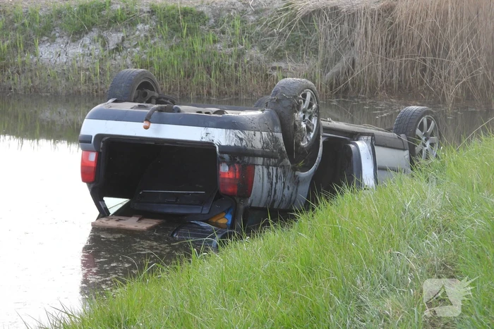 Auto op zijn kop in de sloot