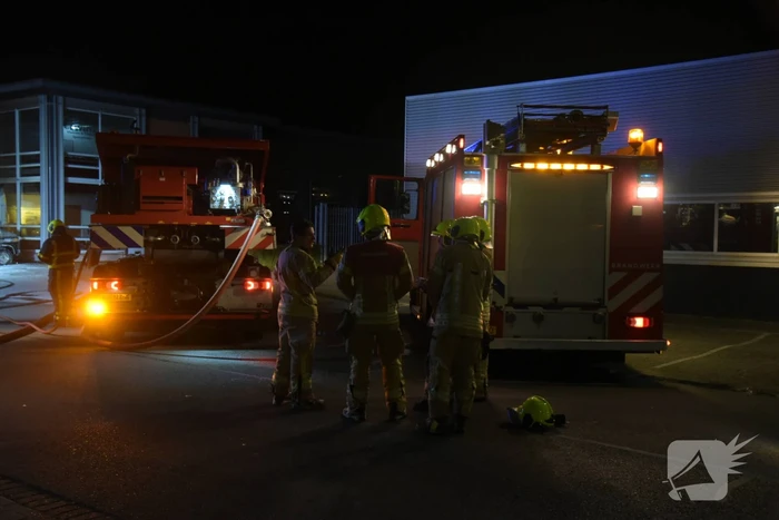Meerdere voertuigen in brand tegen gevel bedrijfspand