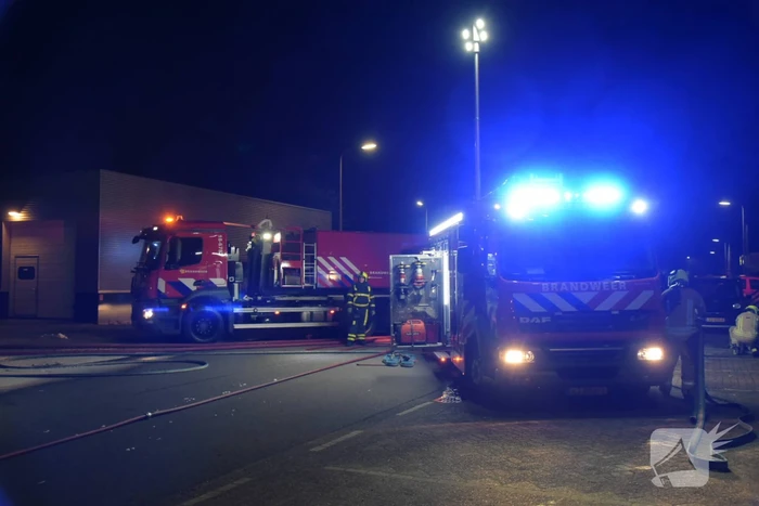 Meerdere voertuigen in brand tegen gevel bedrijfspand