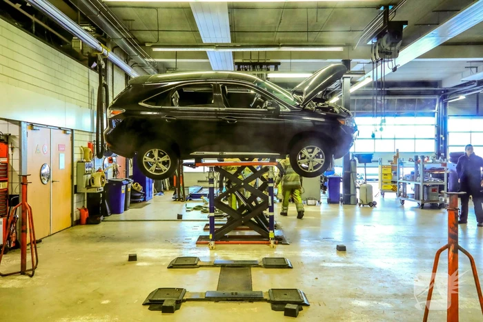 Auto dreigt van hefbrug Toyota Louwman af te vallen