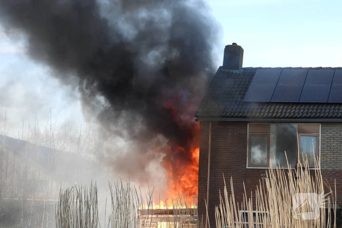 Uitslaande brand in schuur tegen woning aan