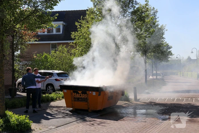 Bewoners blussen brand in bouwcontainer met puin