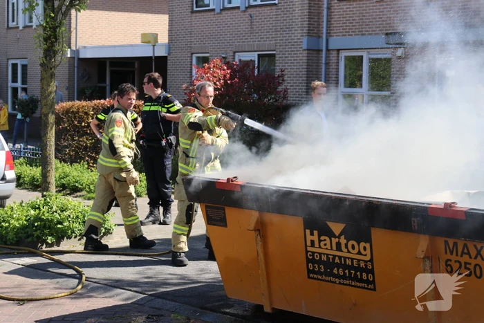 Bewoners blussen brand in bouwcontainer met puin